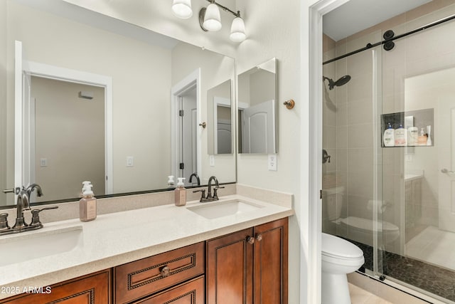 bathroom with a sink, toilet, and a shower stall