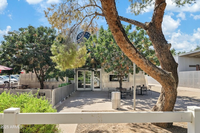 view of front facade featuring french doors, a patio area, and fence