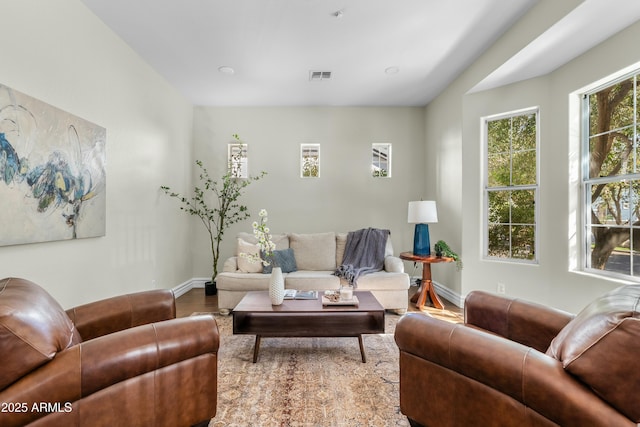 living area featuring visible vents, baseboards, and wood finished floors