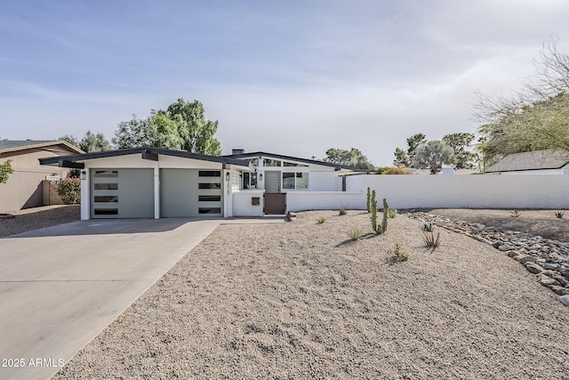 view of front of house with driveway, an attached garage, and fence