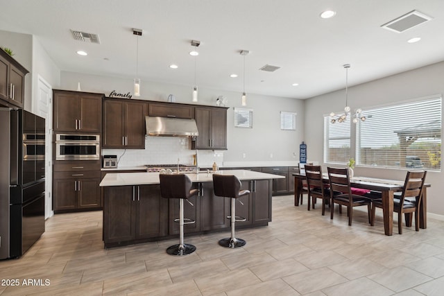 31490 N 126th Ln, Peoria, AZ 85383 - kitchen with light countertops, freestanding refrigerator, under cabinet range hood, visible vents, and stainless steel oven