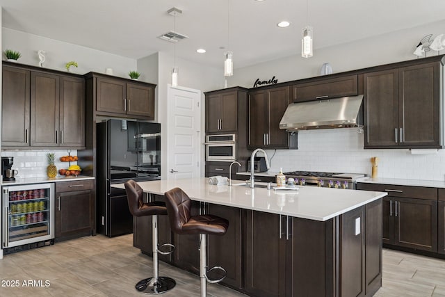 31490 N 126th Ln, Peoria, AZ 85383 - kitchen featuring visible vents, freestanding refrigerator, dark brown cabinetry, under cabinet range hood, and beverage cooler