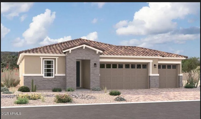 mediterranean / spanish-style home featuring a tiled roof, brick siding, decorative driveway, and an attached garage