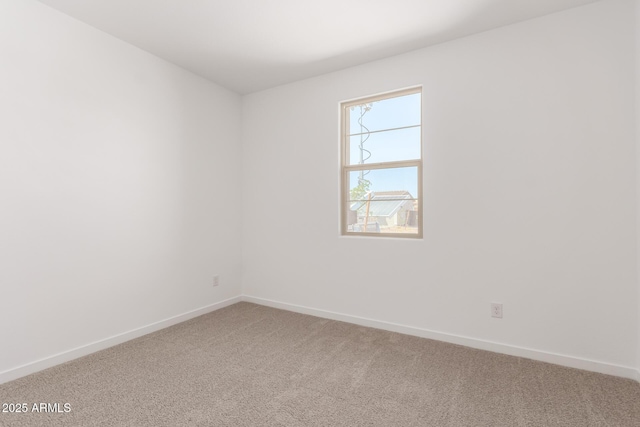 carpeted empty room with baseboards