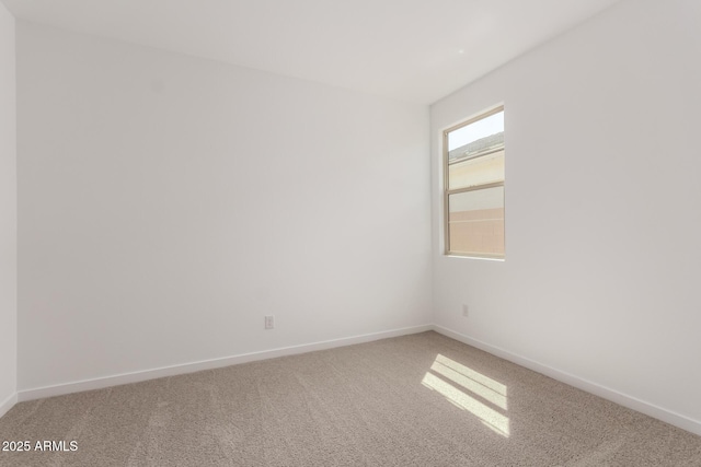 unfurnished room with baseboards and light colored carpet