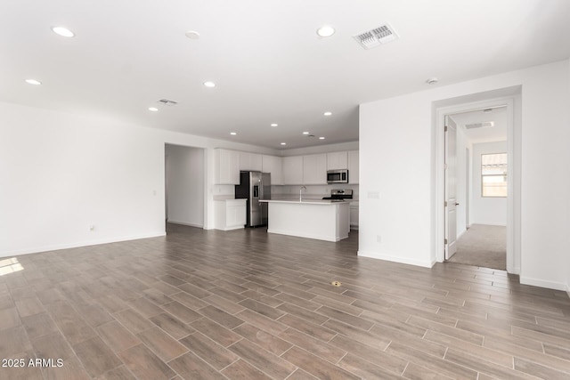 unfurnished living room featuring light wood-type flooring, baseboards, visible vents, and recessed lighting