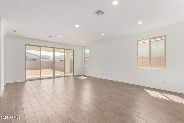 unfurnished room featuring recessed lighting, light wood-type flooring, visible vents, and baseboards