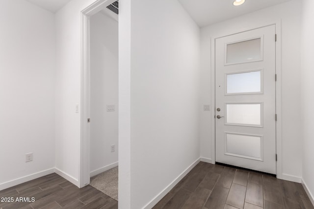 doorway to outside with visible vents, baseboards, and dark wood finished floors