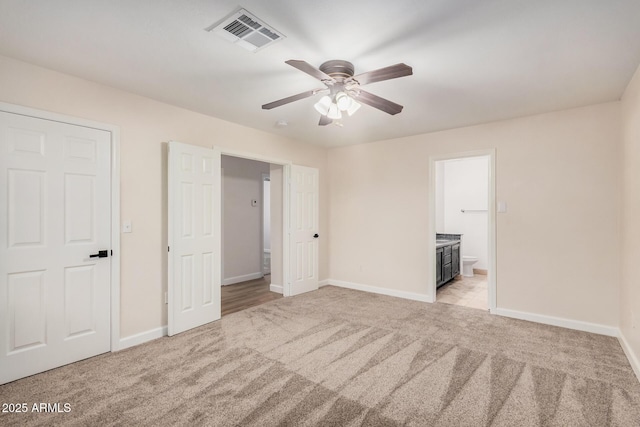 unfurnished bedroom with light carpet, baseboards, ensuite bathroom, and a ceiling fan