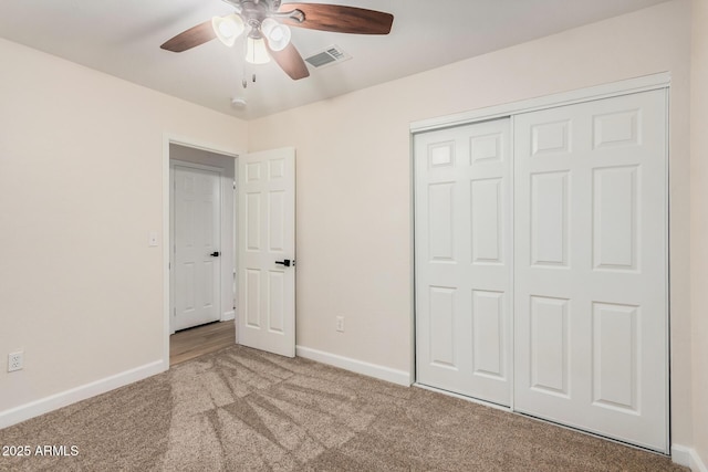 unfurnished bedroom with carpet flooring, baseboards, a closet, and a ceiling fan