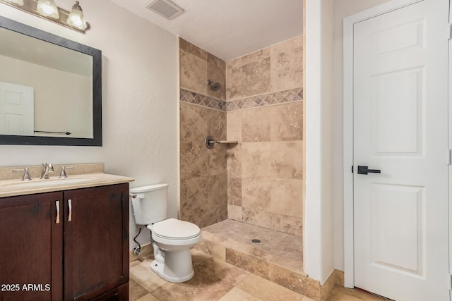 full bath with vanity, toilet, and a tile shower