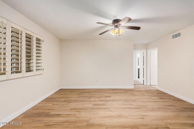 spare room with ceiling fan, light wood-style floors, and baseboards
