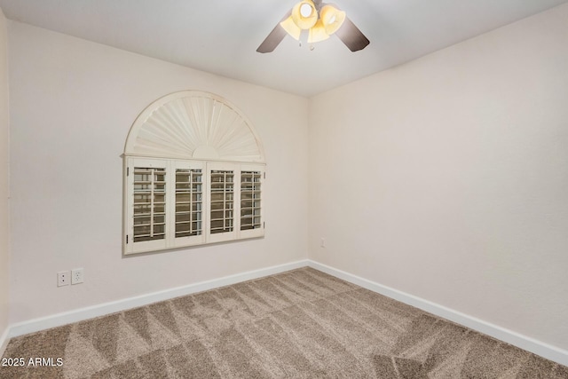 carpeted spare room featuring ceiling fan and baseboards