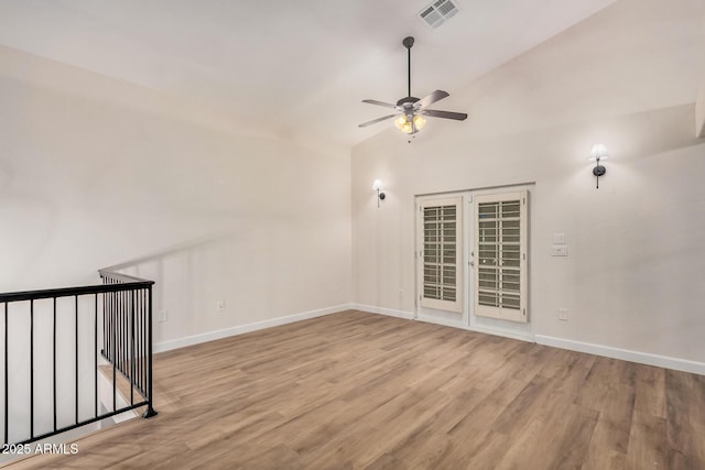 unfurnished room with ceiling fan, wood finished floors, baseboards, french doors, and lofted ceiling