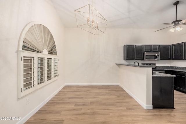 kitchen featuring stainless steel appliances, dark cabinetry, a ceiling fan, and light wood-style flooring