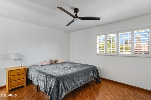 bedroom featuring a ceiling fan, baseboards, and wood finished floors