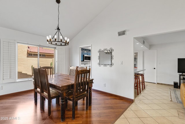 dining room with light wood-style floors, baseboards, and a chandelier