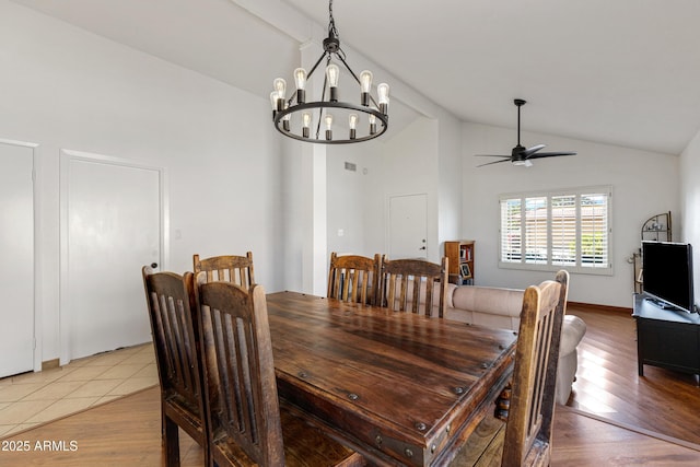 dining area featuring light wood-style flooring, ceiling fan with notable chandelier, and high vaulted ceiling