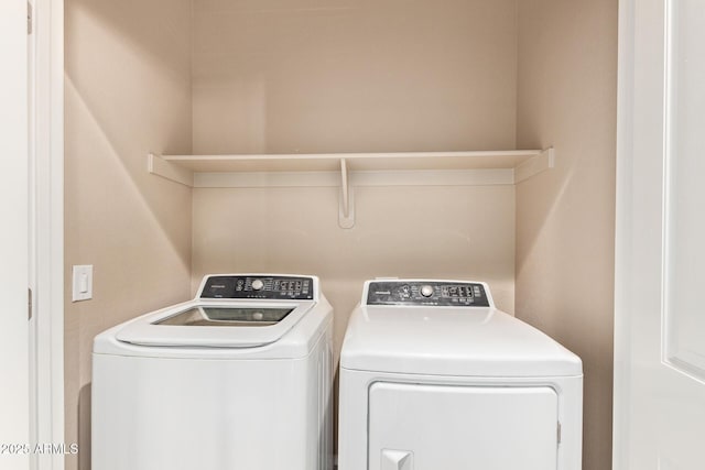 clothes washing area with washing machine and dryer