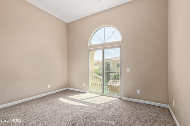 carpeted empty room featuring baseboards