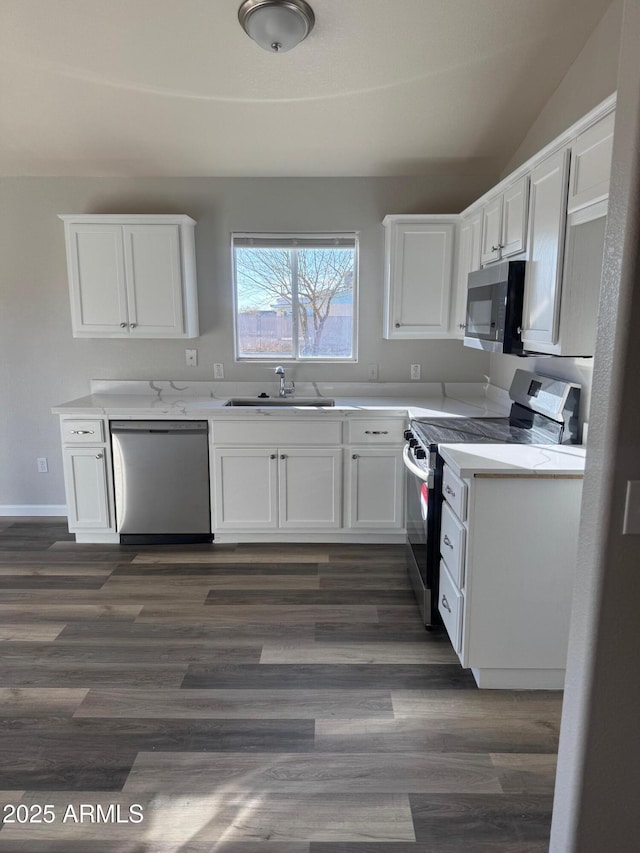 kitchen featuring white cabinetry, appliances with stainless steel finishes, dark wood-type flooring, and sink