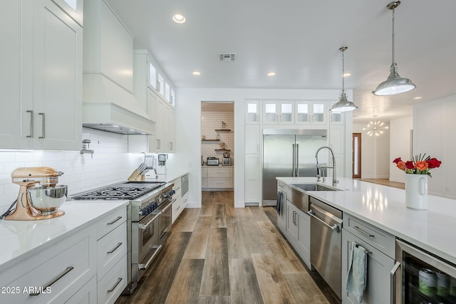 22709 S 202nd St, Queen Creek, AZ 85142 - kitchen with high quality appliances, wine cooler, custom range hood, dark wood-type flooring, and tasteful backsplash