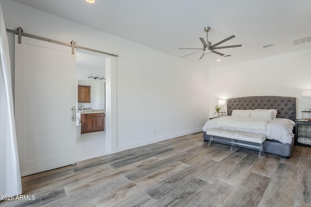 22709 S 202nd St, Queen Creek, AZ 85142 - bedroom featuring light wood-style floors, a barn door, connected bathroom, recessed lighting, and baseboards