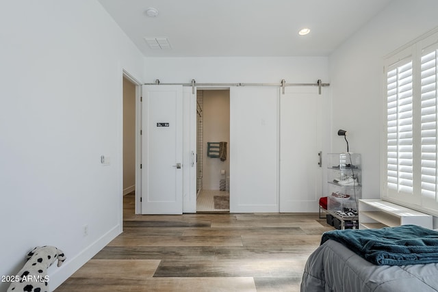 22709 S 202nd St, Queen Creek, AZ 85142 - bedroom with a barn door, wood finished floors, and recessed lighting