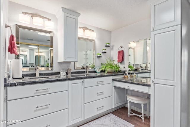 bathroom with vanity, hardwood / wood-style flooring, and a textured ceiling