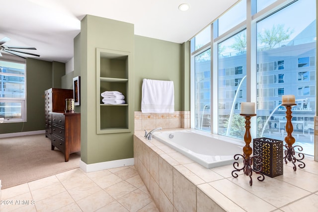 bathroom with tiled bath, ceiling fan, and tile patterned flooring