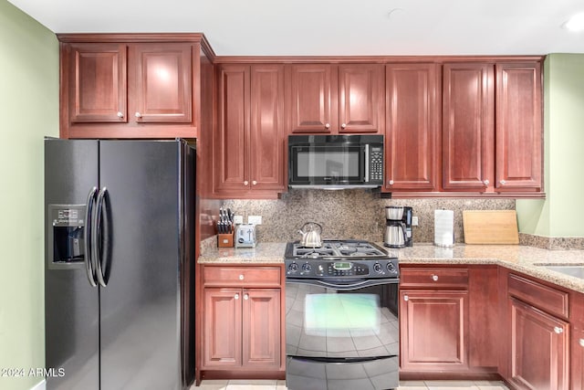 120 E Rio Salado Pkwy Unit 201, Tempe, AZ 85281 - kitchen featuring black appliances, light stone counters, backsplash, reddish brown cabinets, and light tile patterned floors