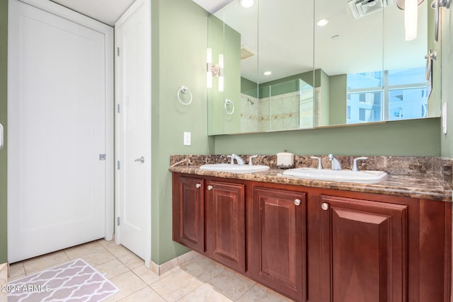 bathroom featuring tile patterned flooring, vanity, and a shower with shower door