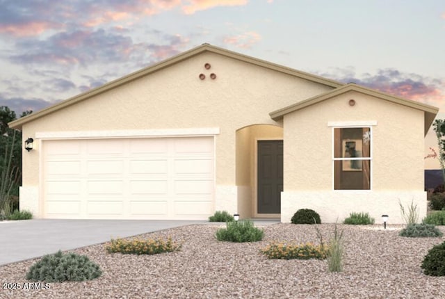 view of front of property featuring a garage, concrete driveway, and stucco siding