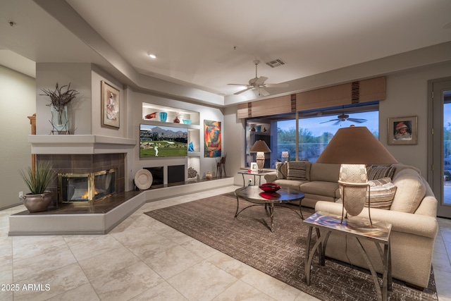 living room featuring built in features and ceiling fan