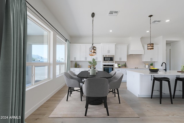 dining area featuring plenty of natural light, sink, and light wood-type flooring