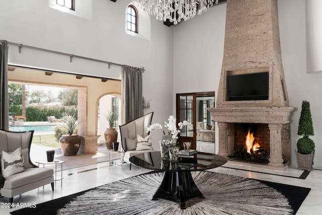 interior space with a towering ceiling, a large fireplace, and light tile flooring