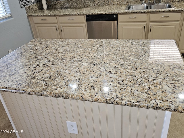 kitchen featuring dishwasher, light stone countertops, sink, and cream cabinets