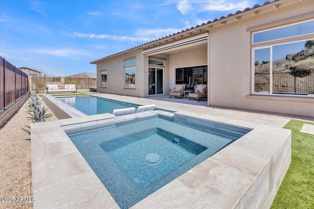 view of swimming pool featuring a patio area, a pool with connected hot tub, and a fenced backyard