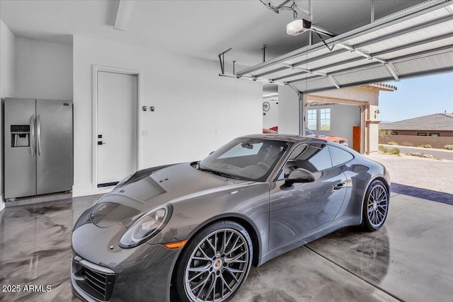 garage with a garage door opener and stainless steel refrigerator with ice dispenser