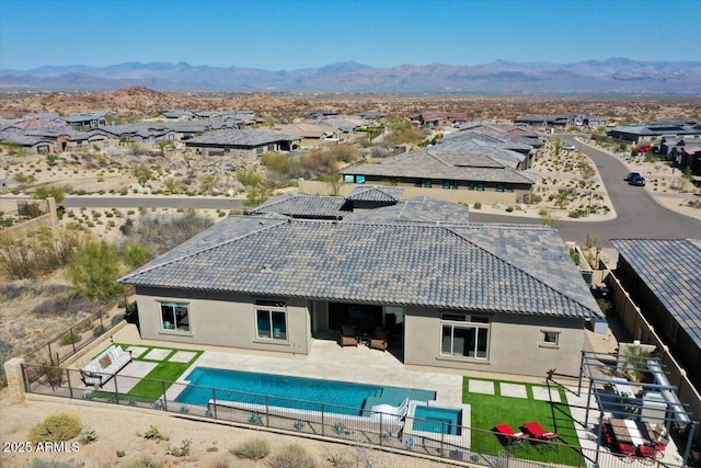 exterior space featuring a fenced backyard, a fenced in pool, a mountain view, and a patio