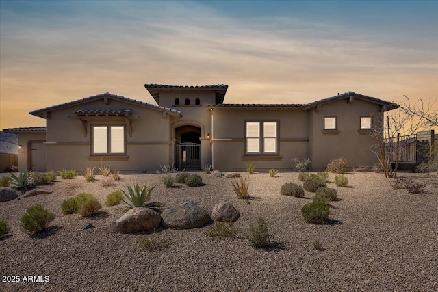 mediterranean / spanish-style home with stucco siding and a tile roof