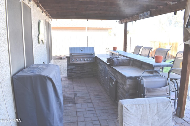 view of patio featuring grilling area, exterior kitchen, and fence