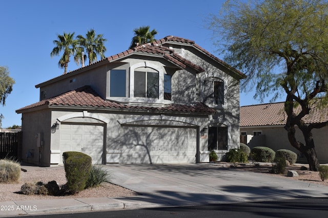 mediterranean / spanish home featuring stucco siding, concrete driveway, and a tiled roof