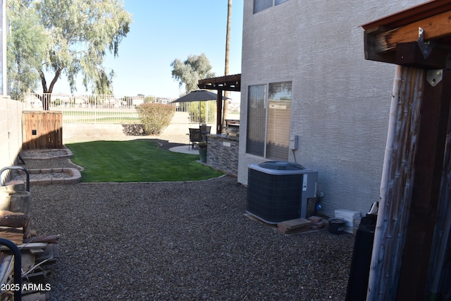 view of yard featuring a patio area, central air condition unit, and fence