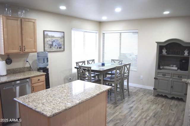 kitchen with light stone counters, recessed lighting, dishwasher, light wood-type flooring, and a center island