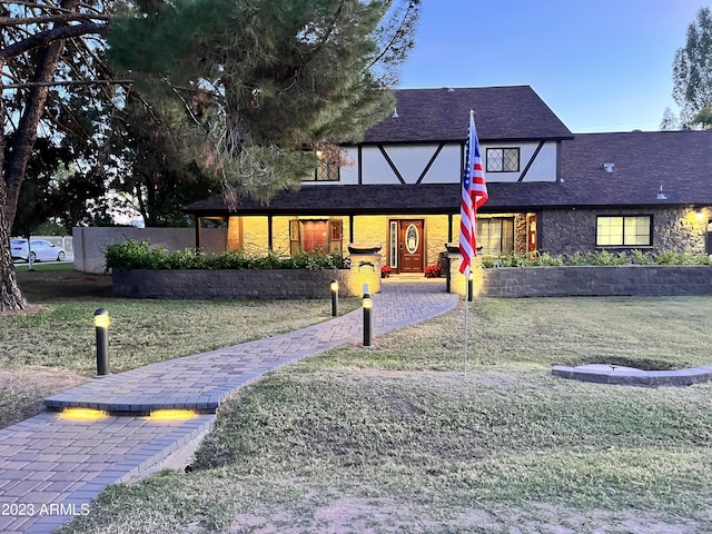 english style home featuring a front lawn