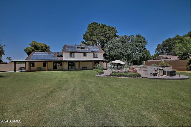 rear view of house featuring solar panels and a yard