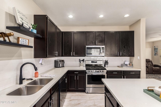 kitchen with dark brown cabinetry, sink, decorative backsplash, and stainless steel appliances