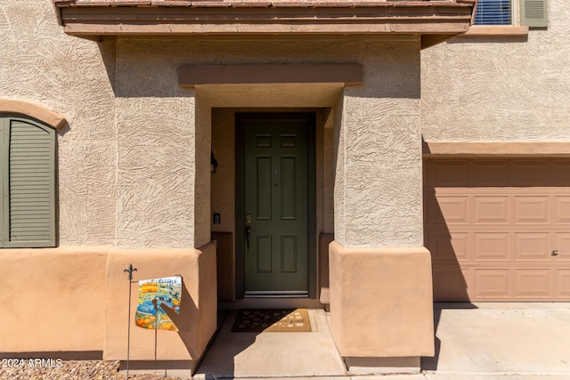 view of exterior entry with a garage