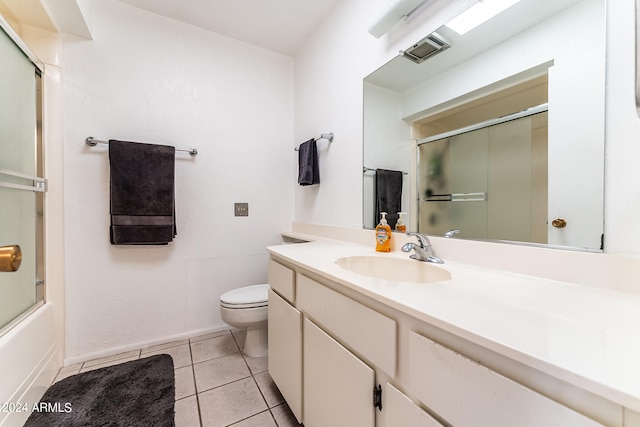 full bathroom with combined bath / shower with glass door, vanity, toilet, and tile patterned floors